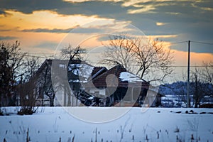 Winter rural scene at sunset with bits of snow