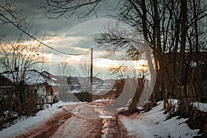 Winter rural scene at sunset with bits of snow