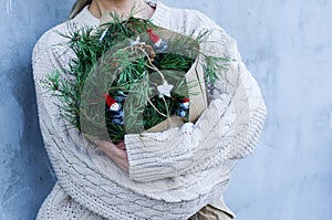 Winter rustic bouquet with fir branches. Female hands holding a Christmas bouquet. New year