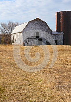 Abandoned Barn and Silo Stand Alone in Winter photo