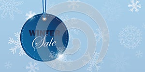 Winter sale blue hanging label on snowy blue background