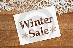 Winter Sale message on a greeting card with white snowflakes