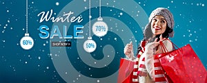 Winter sale message with woman holding shopping bags