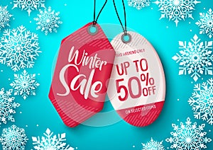 Winter sale tags vector banner. Sale tag with winter discount text hanging in white snowflakes background .