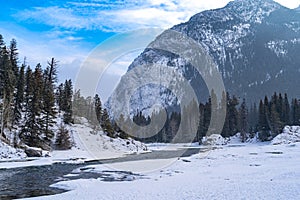 Winter scene of Bow River in Banff National Park with an open river, snow and ice