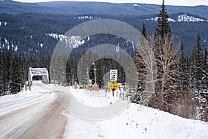 Winter scene of a bridge crossing the Bow River on the snow covered, icy Bow Valley Parkway in Banff National Park Canada
