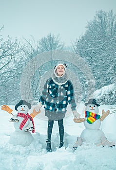 Winter scene with happy people on white snow background. Winter day. Winter woman clothes. Cute snowman at a snowy