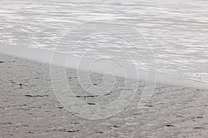 Winter scene showing thin ice and fresh snow at the side of a fast flowing river, danger in spring