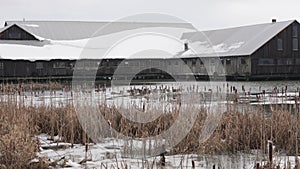 Winter Scene with Snow-Covered Barn and Frozen Pond