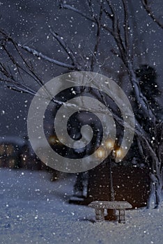 Winter scene with stone bench and street lamps