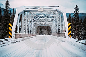 Winter scene of a tresle bridge crossing the Bow River on the Bow Valley Parkway in Banff National Park Canada