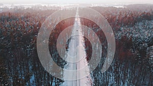 Winter scenery. Car dashing through the snow covered road surrounded by tall leafless trees