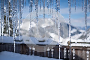 Winter scenery with icicles, cold temperatures and freezing water, blurred Background and blue colors
