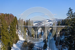 Winter scenery in Silesian Beskids mountains. Railwai viaduct in Wisla Glebce. Aerial view from above. Landscape photo captured