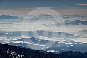 Winter scenery of blue ridges forests and hazy valleys Slovakia