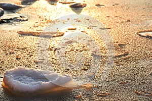 Winter sea in the early morning. frozen water and stones at dawn.