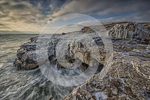 Winter Seascape at sunrise of rocky, frozen coast