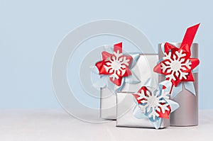 Winter season elegant cold background for advertising and design - silver gift boxes with red and blue silk ribbons, bow.
