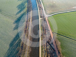 Winter Serenity: Aerial View of River or Canal Amidst Frozen Farm Fields