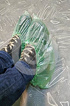 On winter shoes with laces, cellophane green shoe covers.