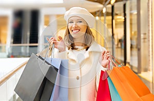 Winter shopping. Cheerful woman with shopping bags at the mall. Happy lifestyle, holiday discounts, sales concept