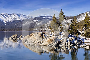 Winter shot of Lake Tahoe with snow on rocks and mountains.