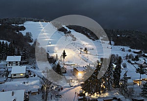 Winter ski slope at night with cable car