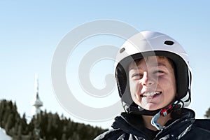 Winter ski vacation in mountains resort, alpine skiing concept. Smiling happy child skier in ski helmet. extreme sport