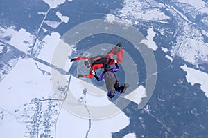 Winter skydiving. Two skydivers are training in the sky.