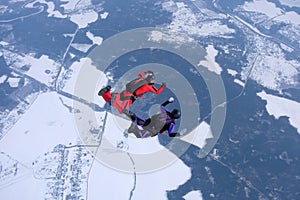 Winter skydiving. Two skydivers are training in the sky.