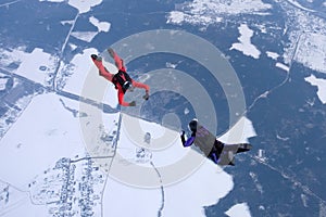 Winter skydiving. Two skydivers are training in the sky.