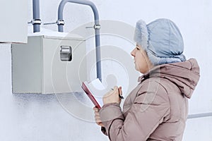 winter, snow, cold. the girl, the engineer, the worker records the readings of the sensors and pressure gauges. They are located