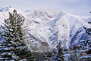 Winter snow-covered forest in the mountains. Mountain peaks covered with snow in winter. Picturesque and gorgeous winter