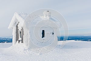 Winter snow covered wood hut. Frozen log cabin in Finland