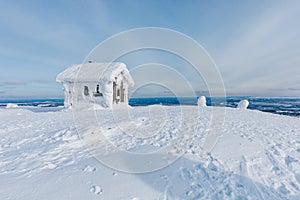 Winter snow covered wood hut. Frozen log cabin in Finland