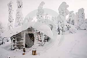 Winter snow covered wood hut. Frozen log cabin in Finland