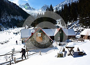 Trekker leaving a chalet in Fagaras mountains.