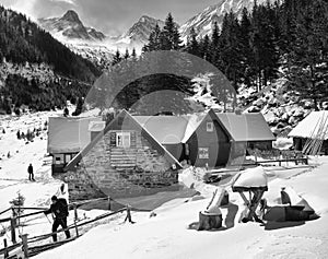 Trekker leaving a chalet in Fagaras mountains.