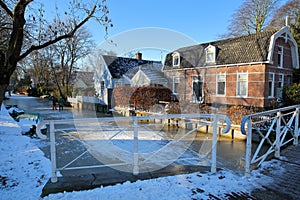 Winter snow and frozen canals in Broek in Waterland, a small town with traditional old and painted wooden houses