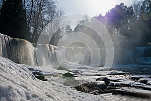 Winter snow landscapes, frozen waterfall and icicles view. Cold wintertime. Stunning frozen waterfall icicles on winter day