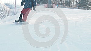 Winter snowboarding - A man with modern prosthetic leg skating down the mountain and slows down in front of the camera