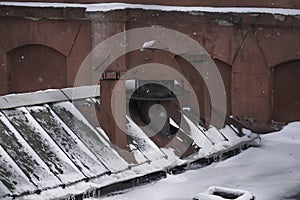 Winter, snowfall. Photo of the old factory. windows and roof of the old factory building. snow-covered old factory