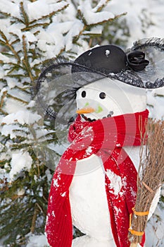 Winter - snowman in a snowy landscape with a hat and a red scarf