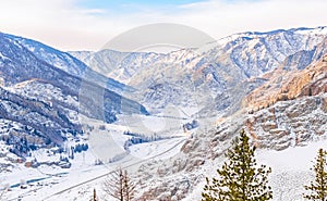 Winter snowy landscape of the valley among the high rocky mountains with a highway