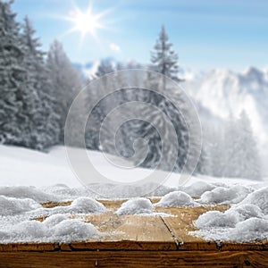Winter and snowy mountains with wooden board backround. Tall spruce covered with snow and sunny sky background.