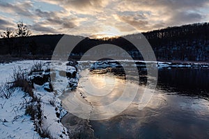 Winter snowy sunset view on river shore, Ukraine