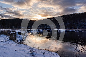 Winter snowy sunset view on river shore, Ukraine