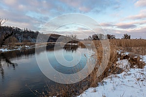 Winter snowy sunset view on river shore, Ukraine