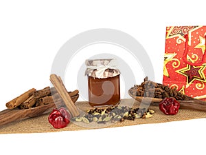 Winter spices and honey glass jar on jute texture with gift bag