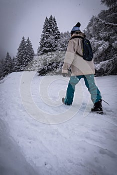 Winter sport activity, Woman hiker hiking with backpack on snow trail forest in Pyrenees, France